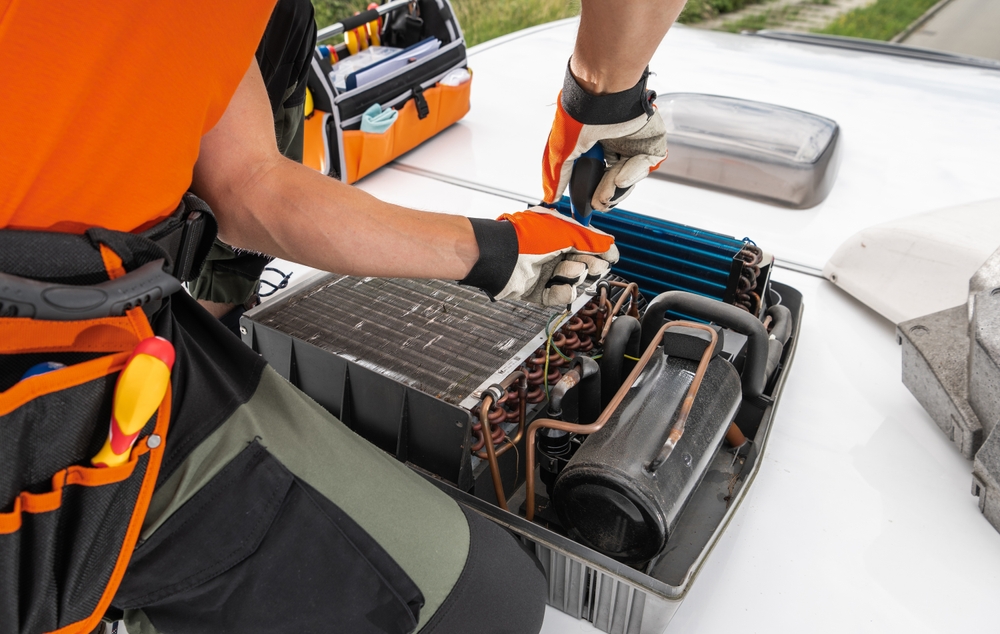 A,technician,adjusts,components,of,a,rooftop,rv,camper,hvac